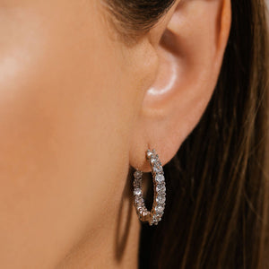 The Cristallo Hoop Platinum sparkles brightly on the model's ear. 