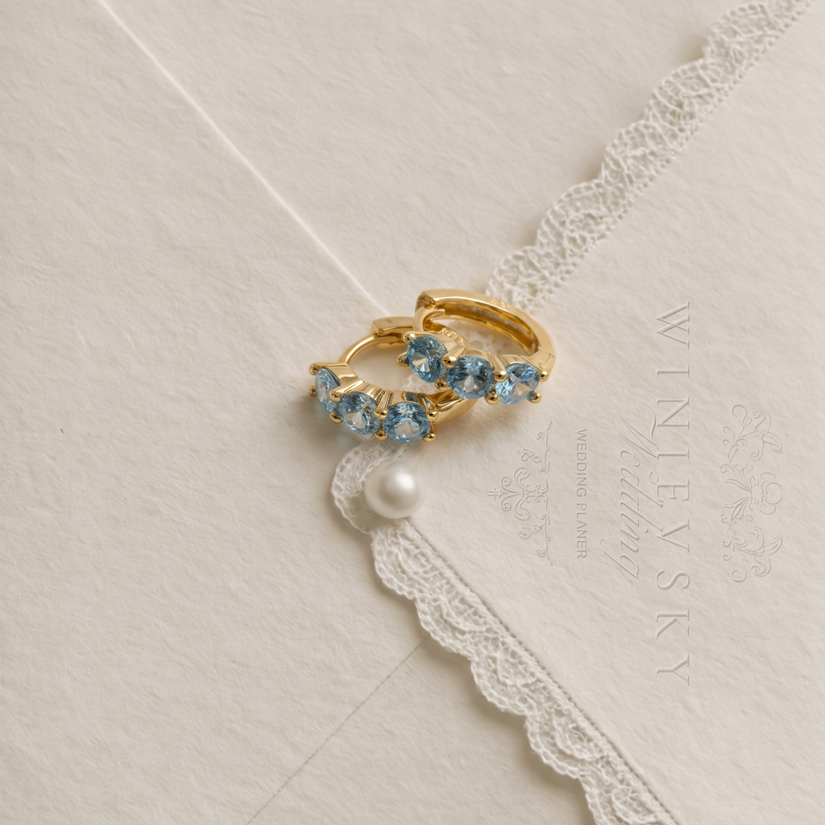 The Perfect Hoop Something Blue bridal jewelry collection featuring blue-toned crystal earrings.