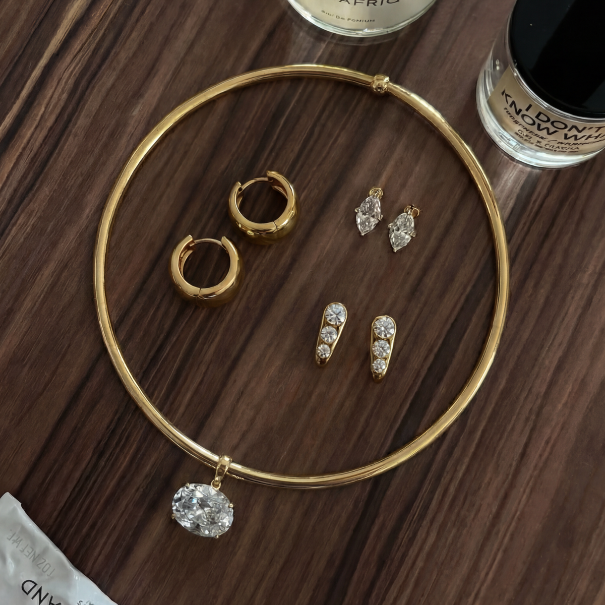 The Perfect Hoop Back in Stock collection image featuring model wearing gold statement earrings, stacked ear cuff, gold pendant necklace, and textured gold ring in warm editorial styling. 