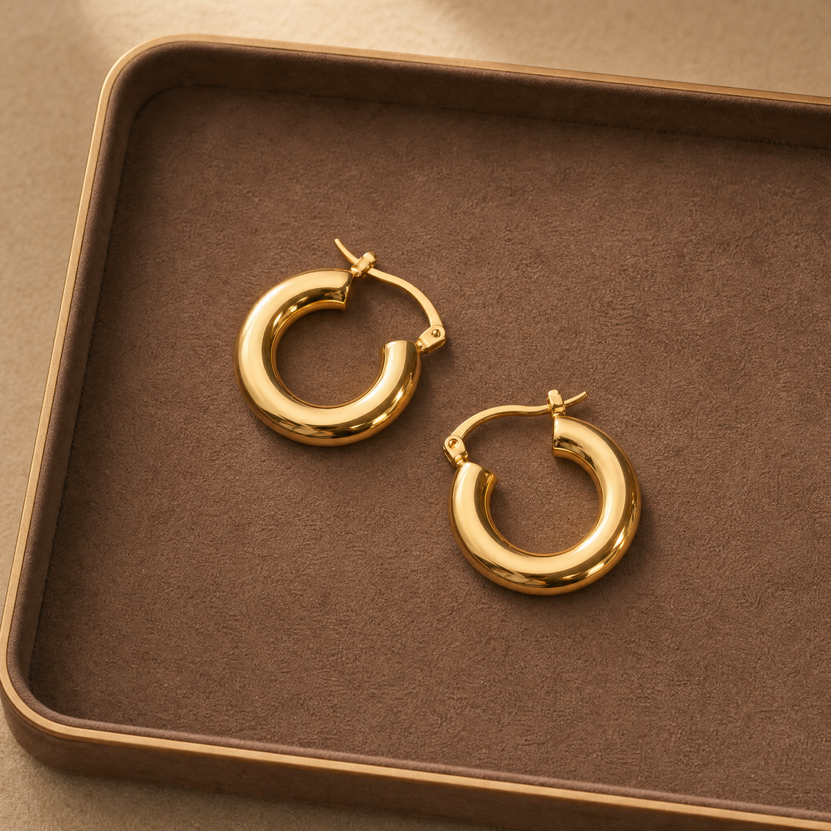 The model shades her eyes with her hand, drawing attention to the golden mid-sized hoop on her ear. 
