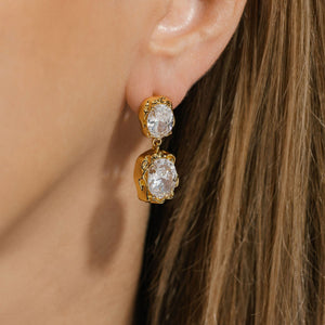 The golden Aura Casila Hoop with two crystal accents is a dazzling accessory on the model's ear. 