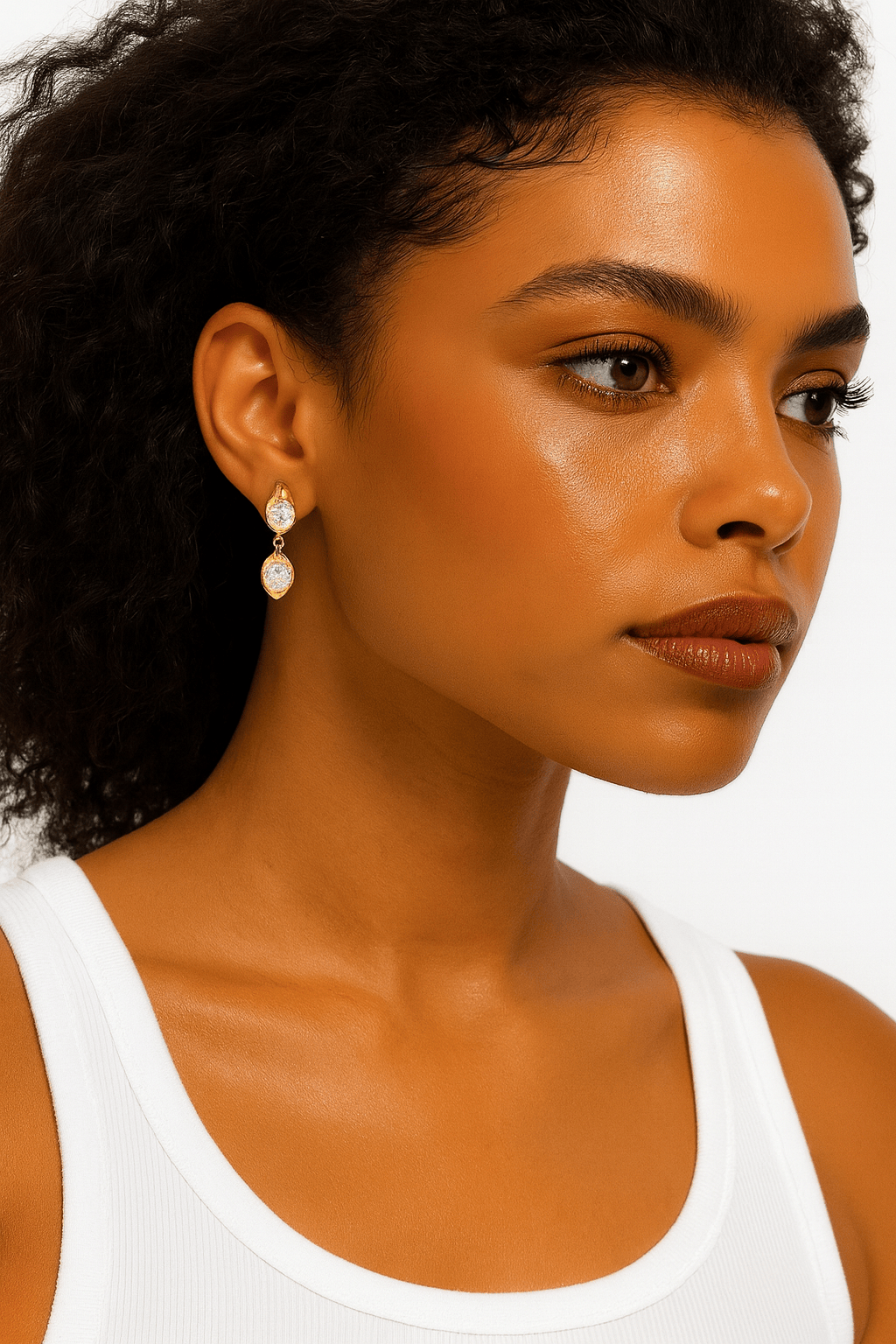Model wearing The Perfect Hoop Aura Mini Earrings in gold, showcasing elegant drop silhouette and crystal detailing.