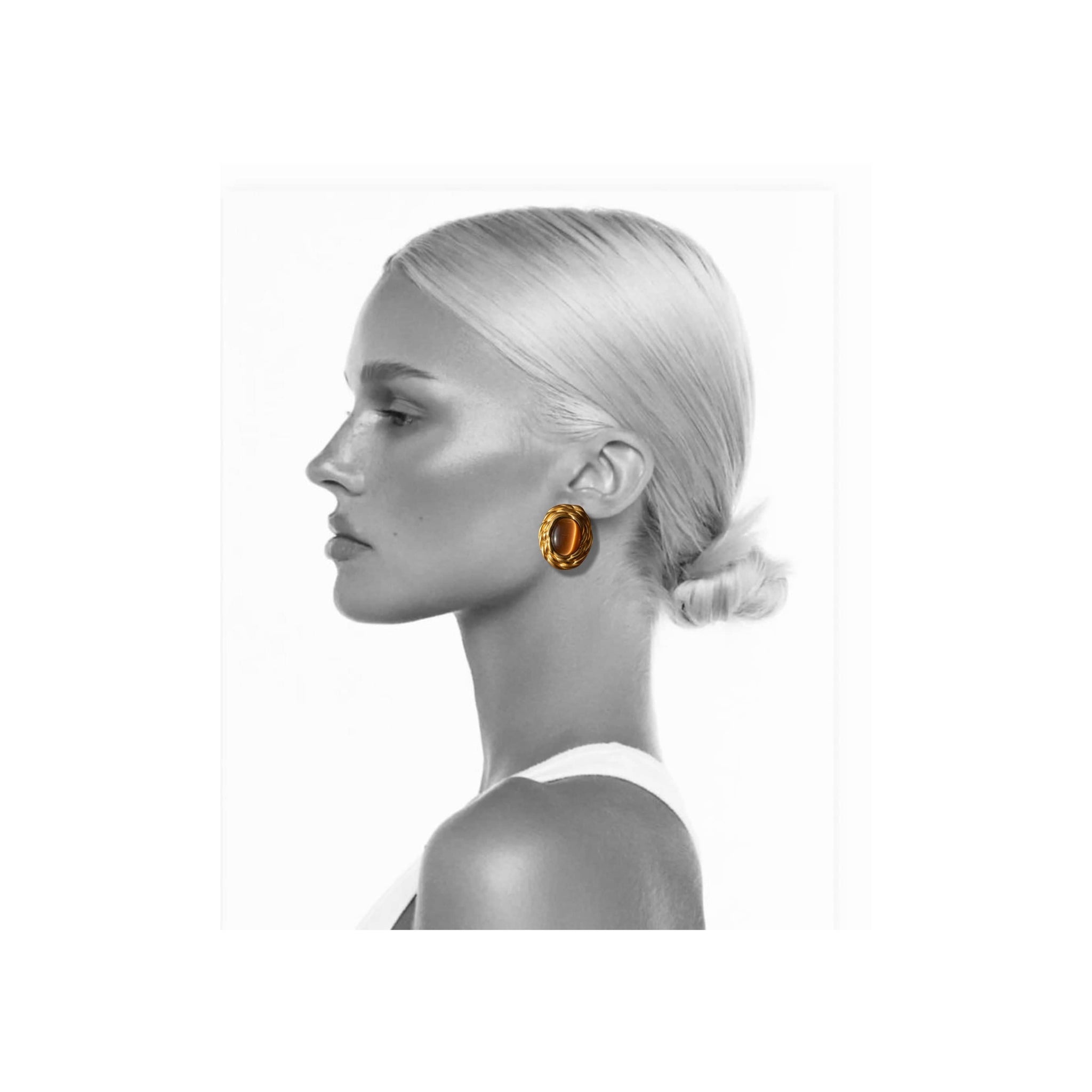 Side profile of a model wearing gold hoop earrings on a white background by The Perfect Hoop.