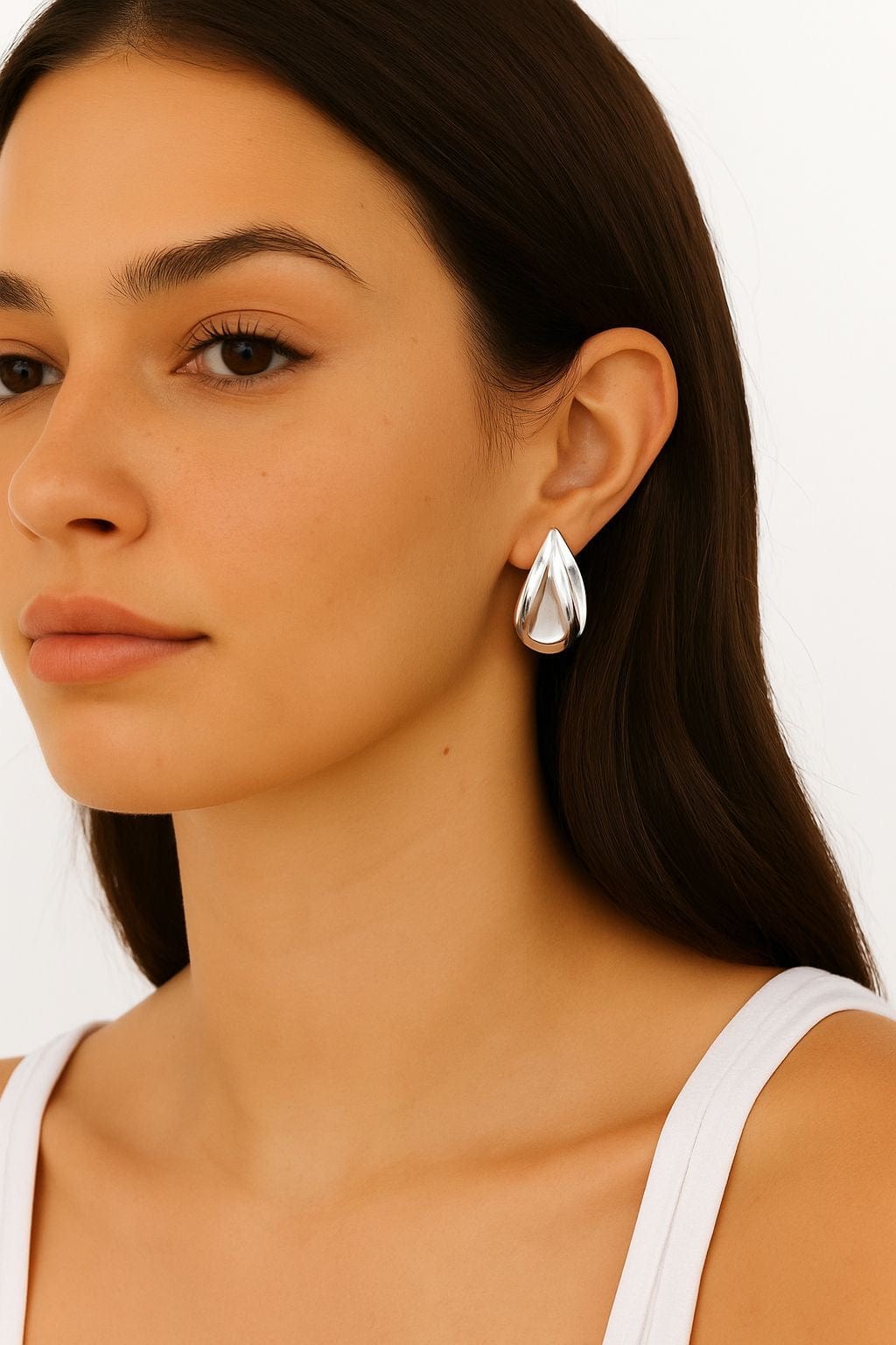 Model wearing a white tank top and silver teardrop Harlow Earring on a white background by The Perfect Hoop.
