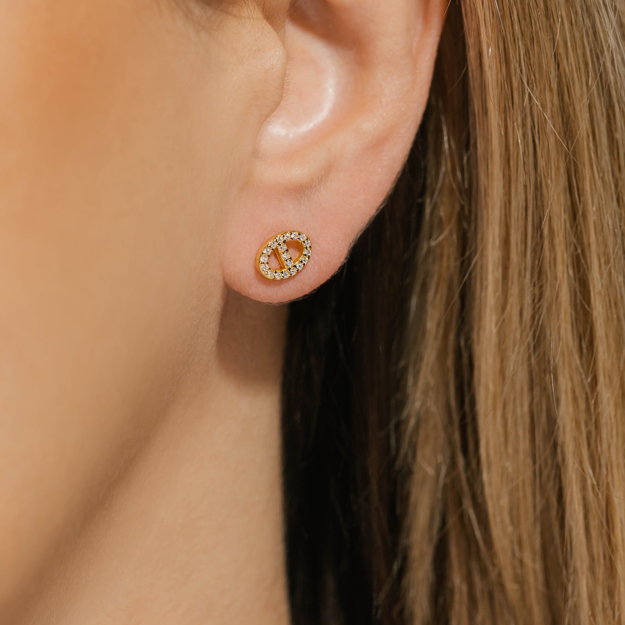 Model wearing The Jolie Stud pavé earrings in gold, featuring a circular design encrusted with sparkling crystals, adding a touch of elegance to the ear. Gold pavé stud earrings by The Perfect Hoop.