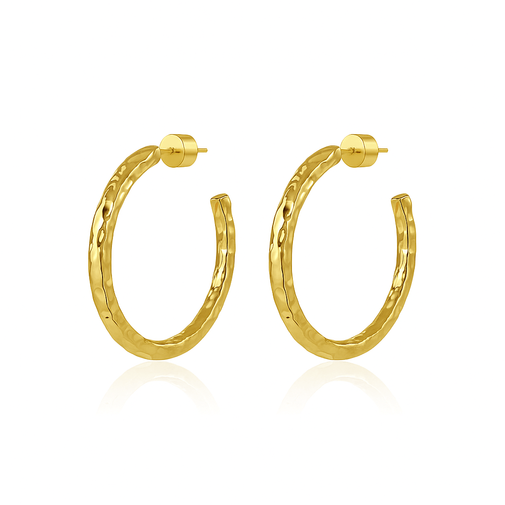 A pair of The Marbella Hoop 50 mm gold earrings with a hammered texture and polished cylinder backings, displayed on a seamless pure white background.