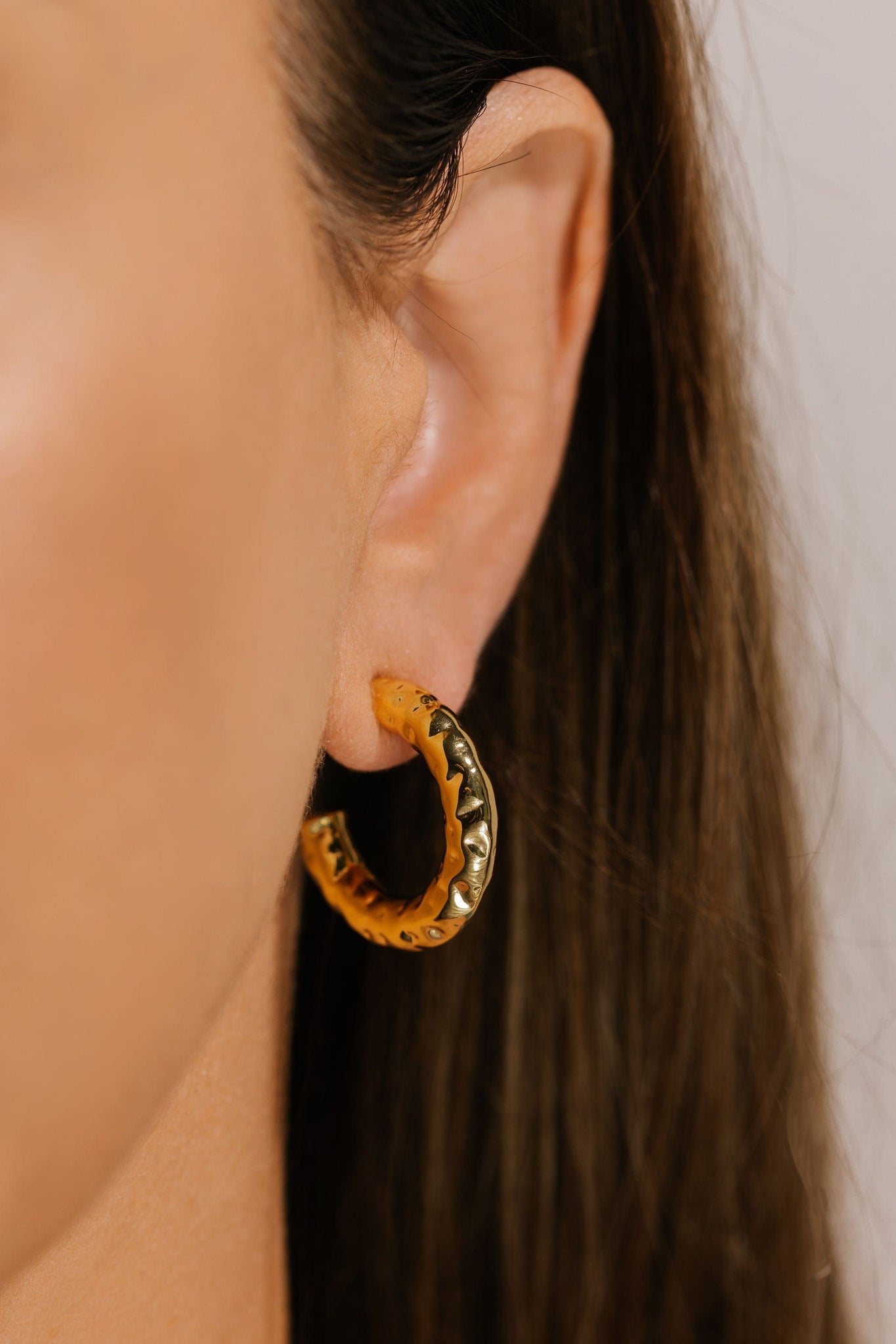 The 25mm Marbella Hoop is a soft, yet elegant accent on the model's ear. 