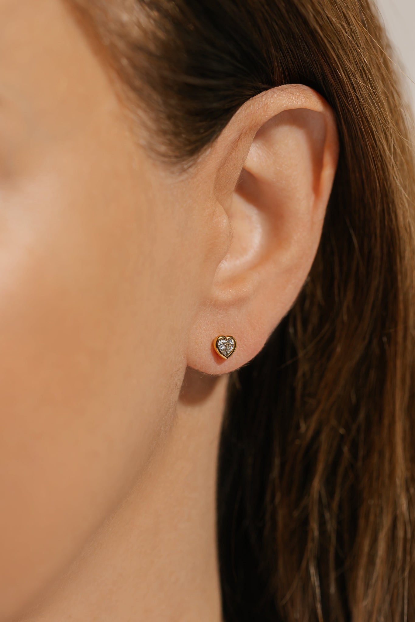 Graceful and poised, the Amore Solitaire Stud earring is a delicate accent on the model's ear. 