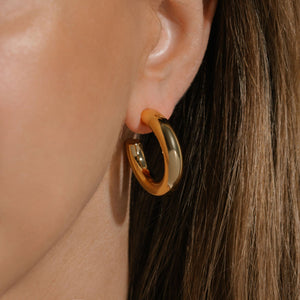 The Perfect Hoop earrings worn by model, showcasing the iconic rounded silhouette and reflective gold finish, a timeless everyday essential.