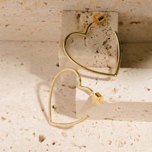 The heart-shaped Amore Hoop earrings feature smooth, elegant lines and secure pushback closures. 