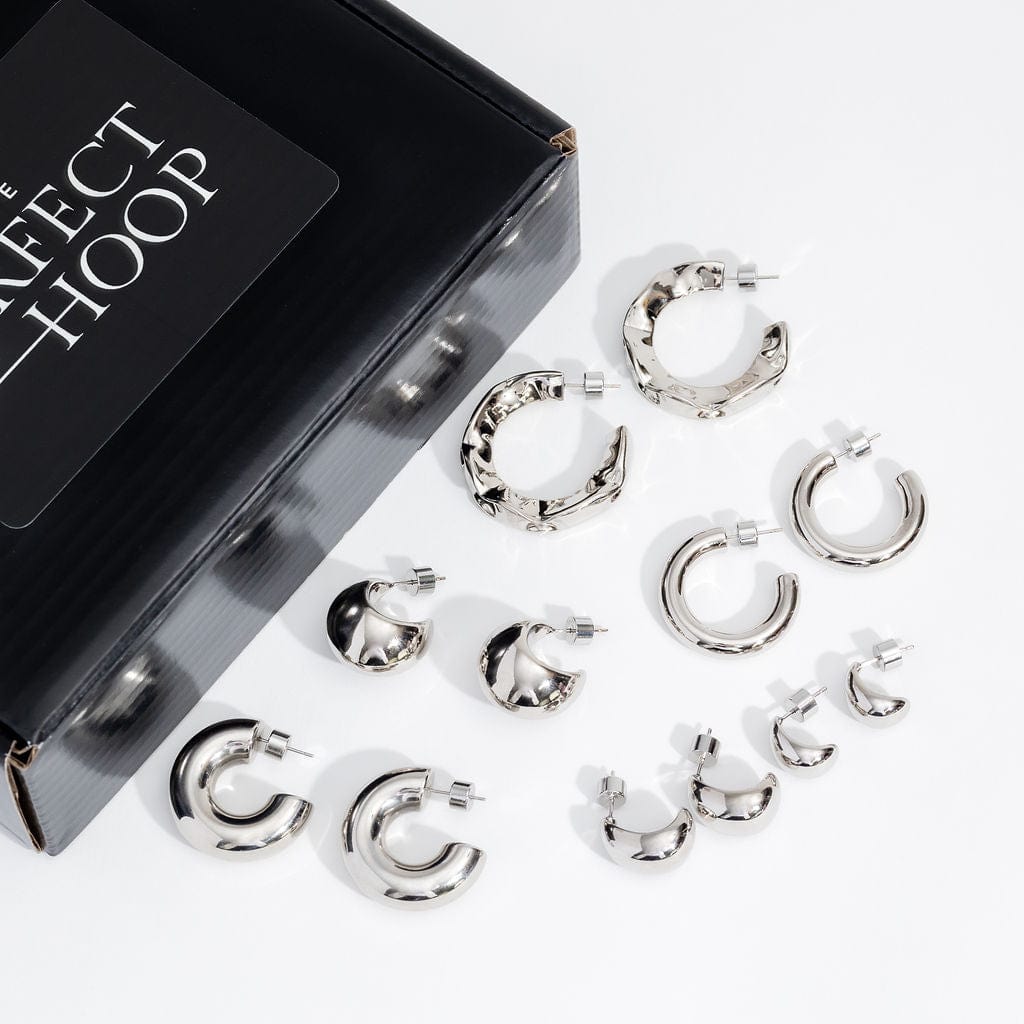 The icy shine of the collection of full-sized open hoop earrings in the Make a Statement Platinum Hoop Starter Pack looks clean and sophisticated against the white surface on which they're displayed.