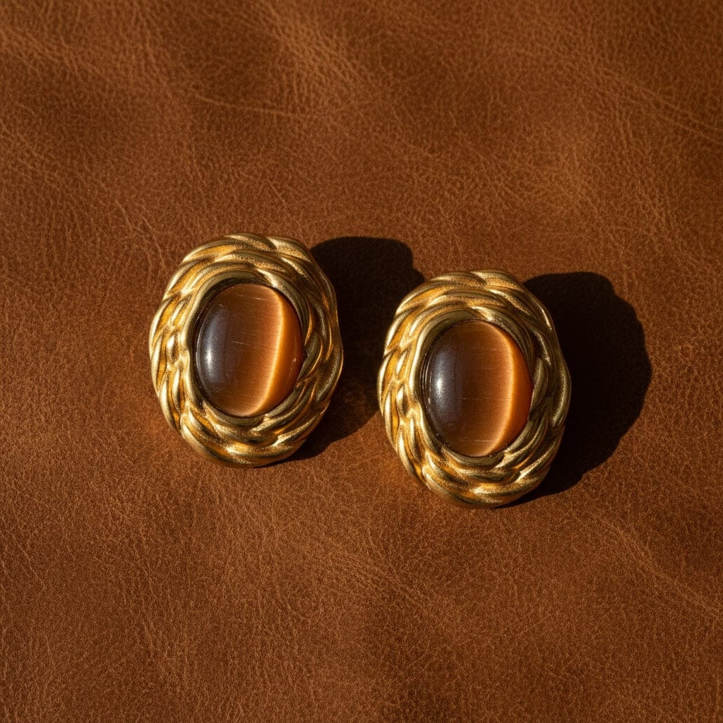  The Perfect Hoop's Hazel Earrings in gold with brown tiger-eye centre stones on a brown leather background.