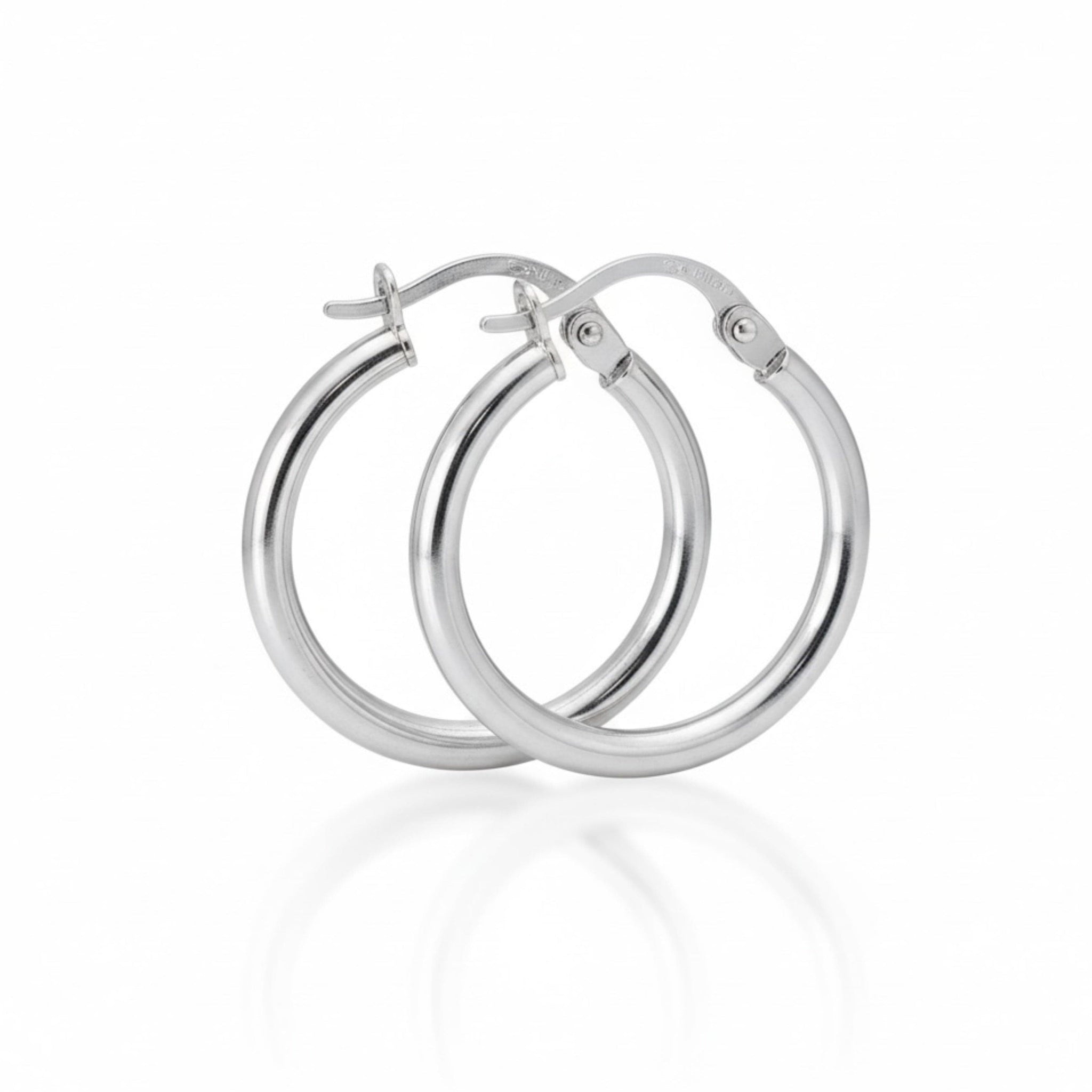 Pair of silver hoop earrings on a white background by The Perfect Hoop.