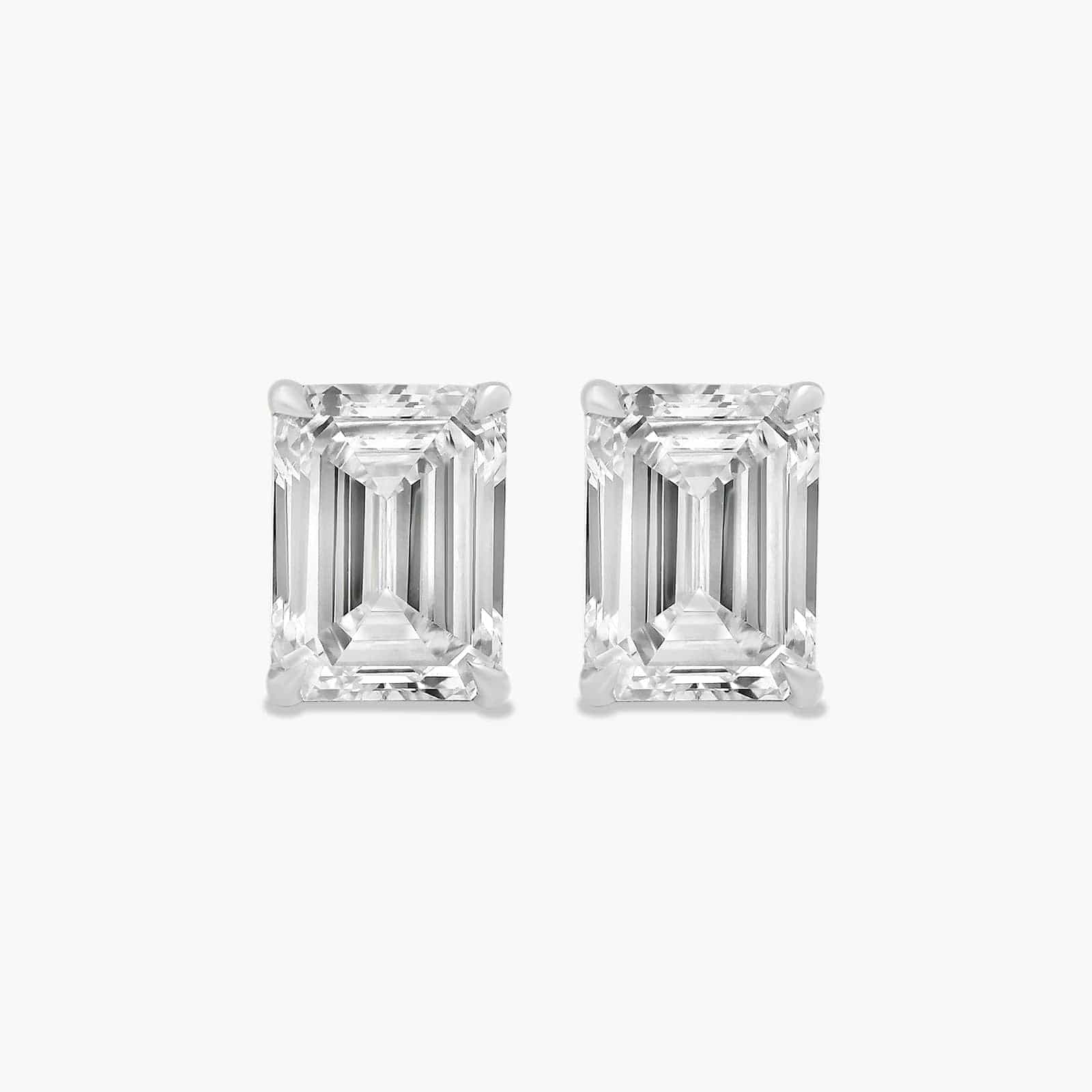 Pair of emerald-cut diamond stud earrings by The Perfect Hoop on a white background