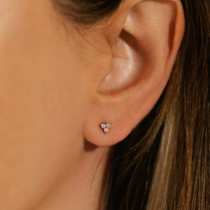 A Stella Stud Platinu earring is worn on the model's ear, the three crystal accents sparkling brightly. 
