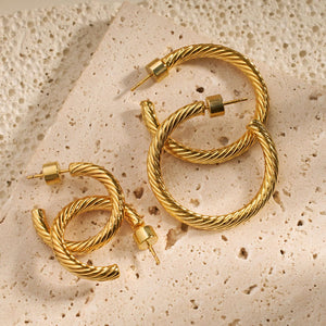 The four open hoops of the Bergamo Hoop Duo lay on a counter, glistening golden in the light. 