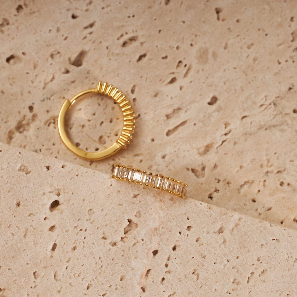 The Baguette Hoop is shown from a top and side view to show off the golden ridged texture between which each baguette stone sits. 