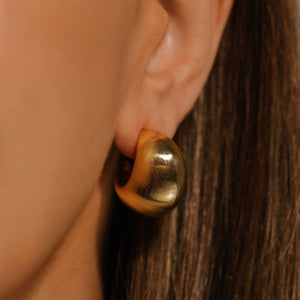 A close-up perspective highlights the bold curve of the dome-shaped Córdoba Hoop Matte as it adorns the model's ear. 